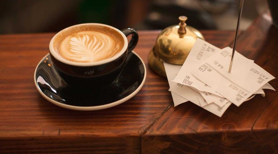 Un café et des tickets de caisse sur un comptoir : chaque addition rapporte des points